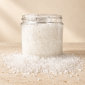 Styled Oatmeal Milk and Honey bath salts mockup: clear jar of white coarse salts on a warm cream studio backdrop