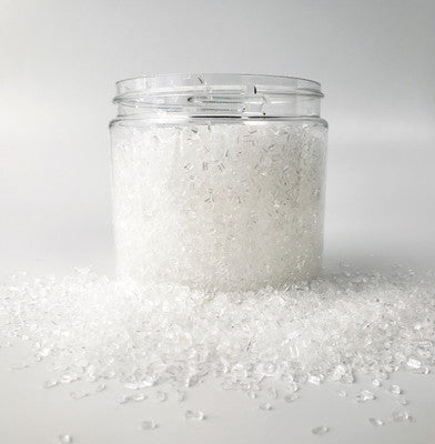 Clear jar of coarse bath salts with lid removed