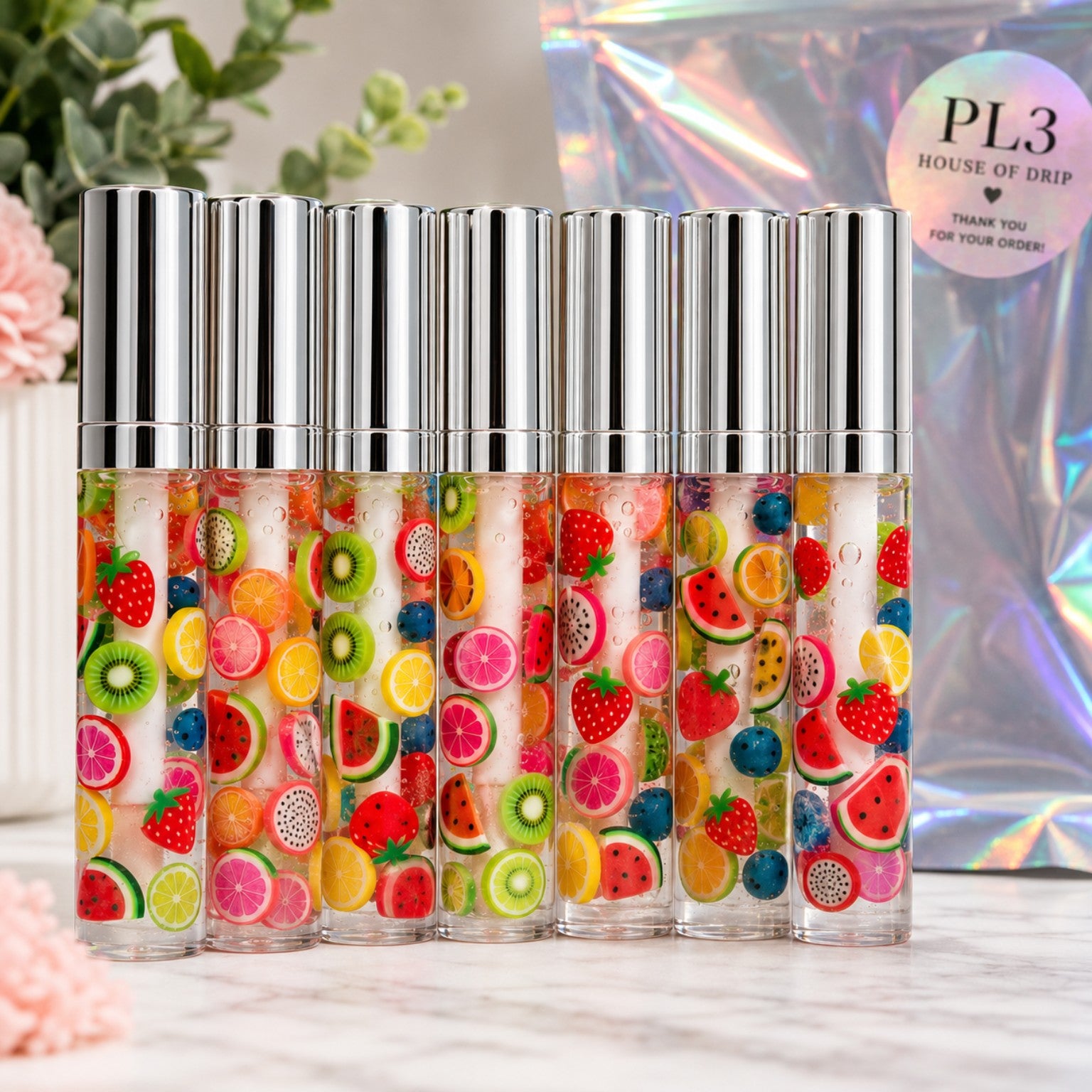 Group display of PL3 Fruity Drip clear lip gloss tubes; each gloss sold individually