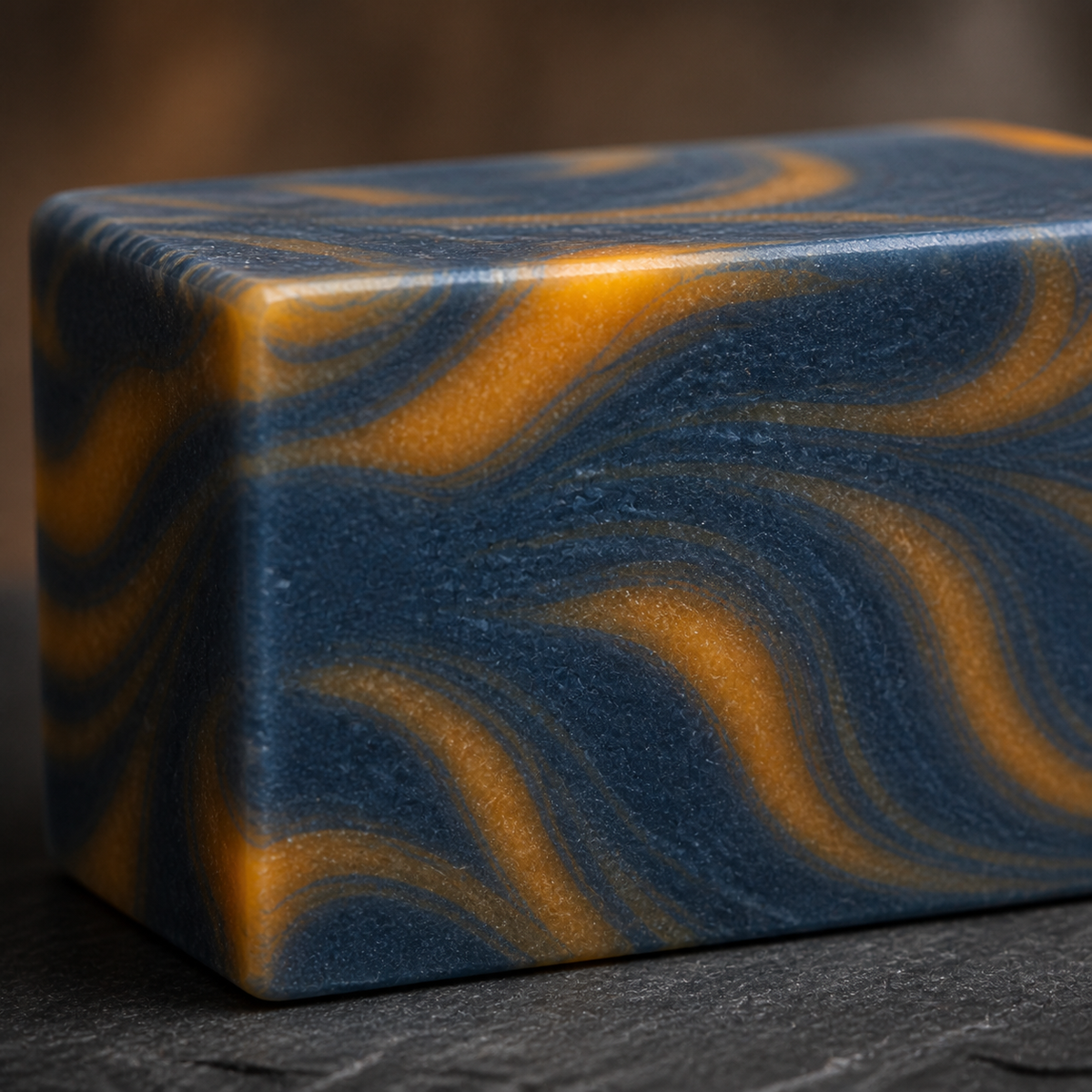 Close-up texture of PL3 Kashmir Scrub soap with navy and gold swirls