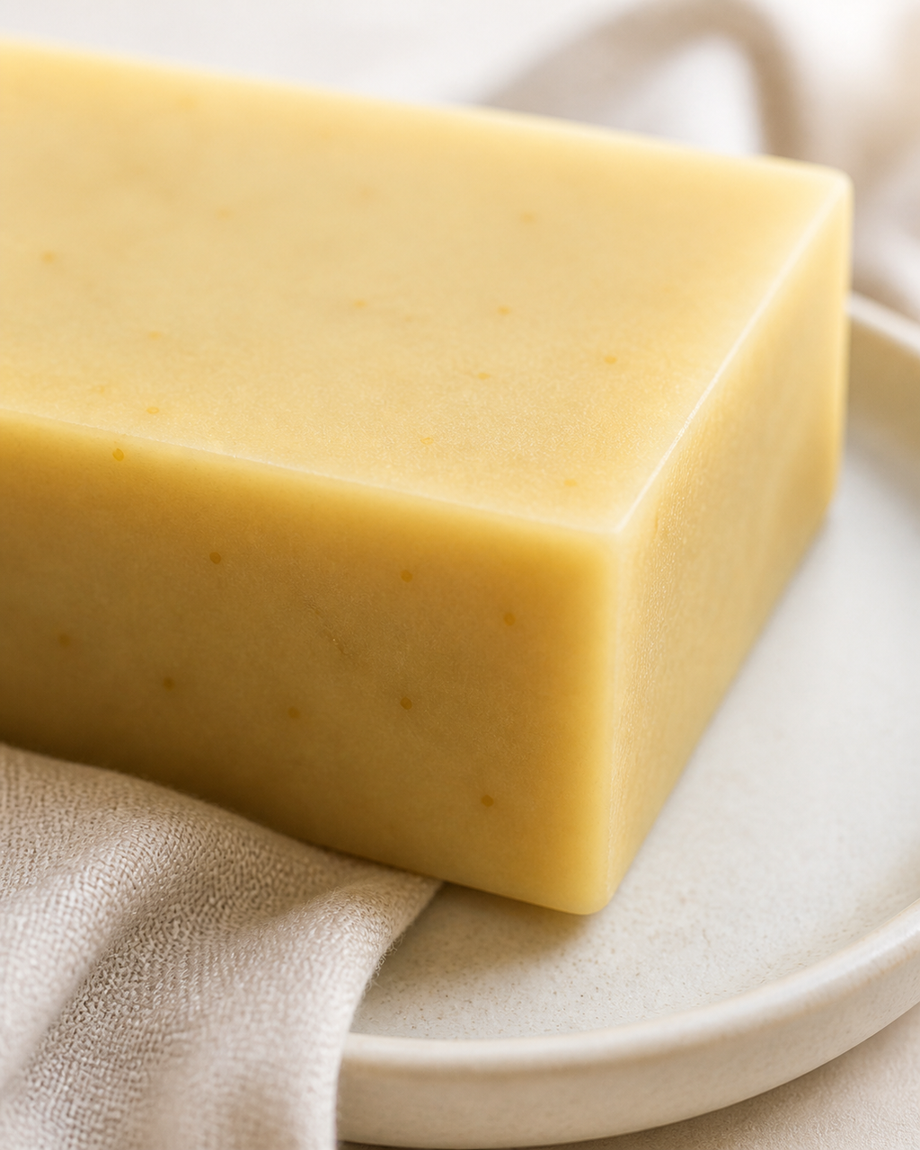 Close-up texture of PL3 Ylang Ylang Lavender cold process soap with botanical flecks